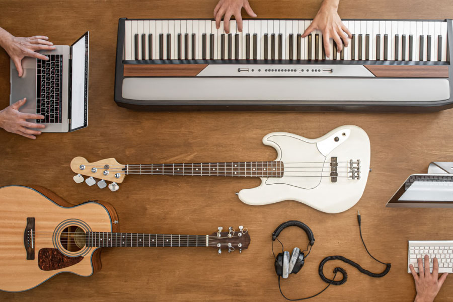 Instruments et outils numériques disposés sur une table pour illustrer la création musicale