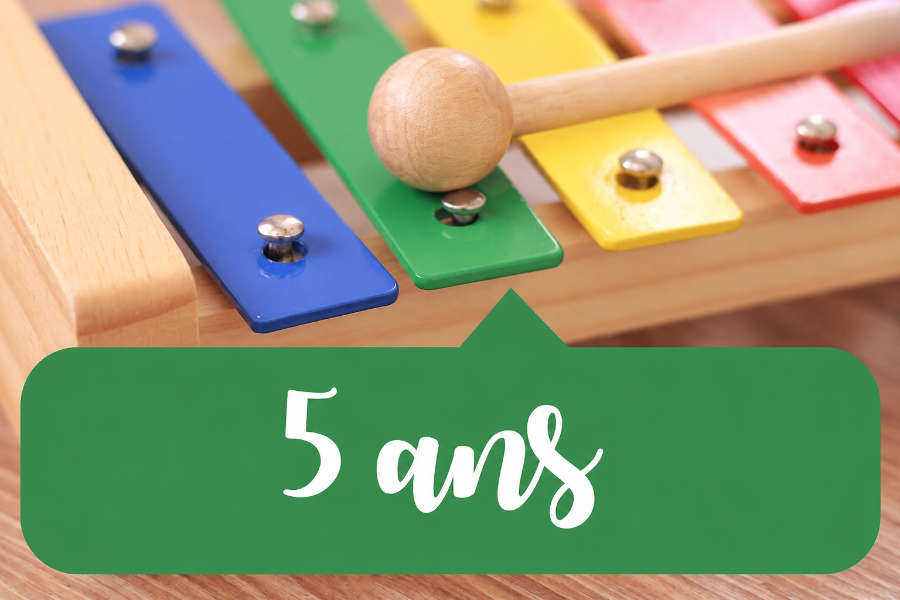 Xylophone coloré avec une baguette posée sur une lame verte, illustrant l’éveil musical 5 ans.
