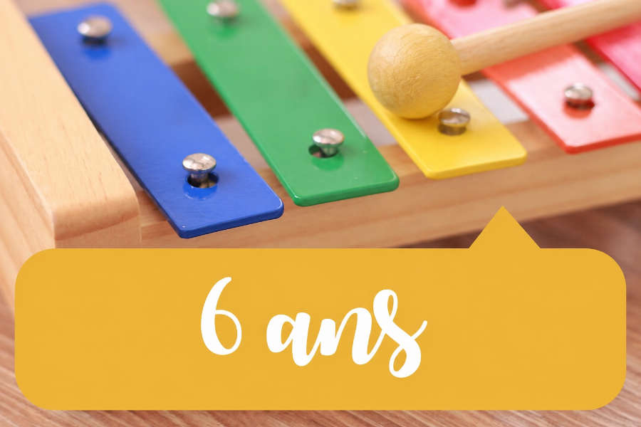 Xylophone coloré avec une baguette posée sur une lame jaune, illustrant l’éveil musical 6 ans.