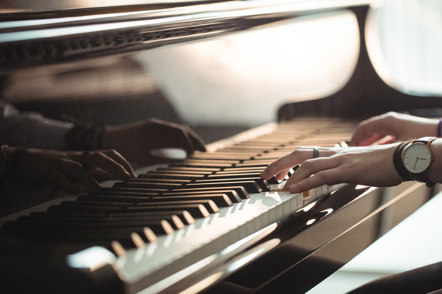 Texte alternatif : Mains jouant sur un piano